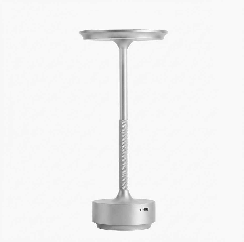 Minimalist cordless rechargeable table lamp in brushed aluminum, featuring a slender stand and a sleek, circular light head, shown against a solid white background.