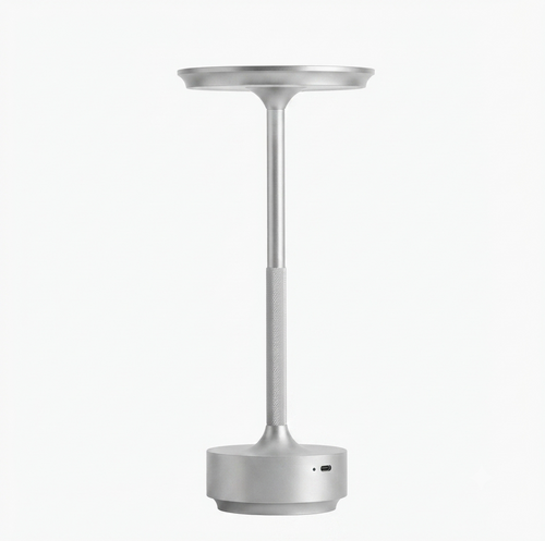 Minimalist cordless rechargeable table lamp in brushed aluminum, featuring a slender stand and a sleek, circular light head, shown against a solid white background.